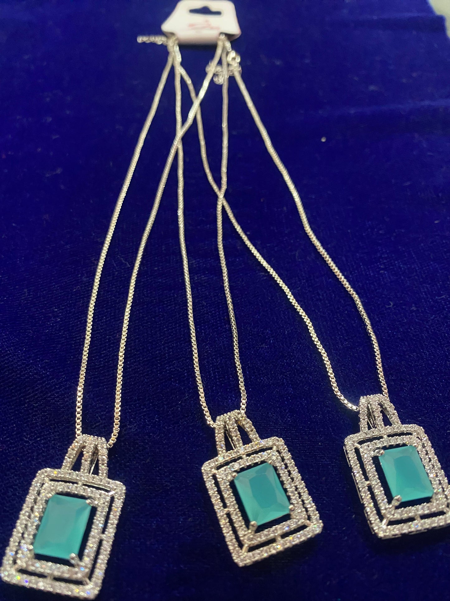 Set of Three square-shaped pendants with teal centers on a silver chain