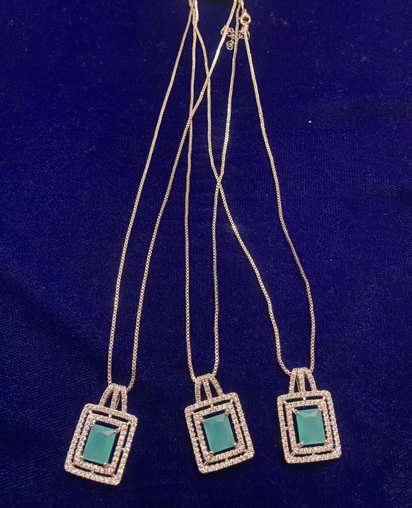 Set of Three square-shaped pendants with teal centers on a silver chain